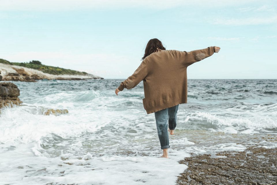 Een vrouw stapt de zee in